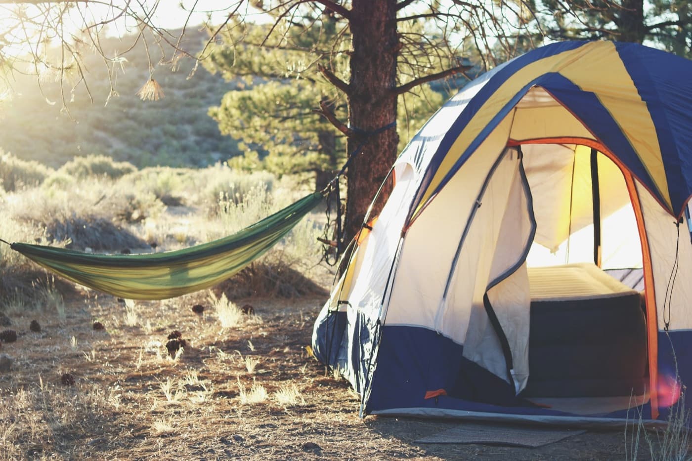 Dome tent pitched in the trees next to a hammock